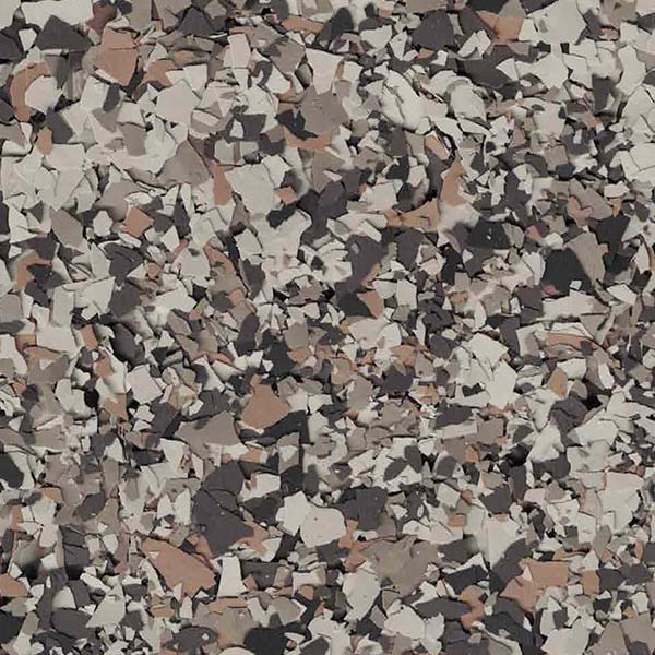 The image depicts a textured surface with an abstract pattern of fragmented shapes in varying shades of brown, grey, and black. It has a granular appearance.