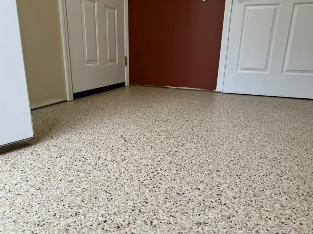 Speckled, polished floor leading to white doors with a contrasting red painted wall. Two closed doors are visible within a small room.